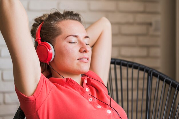 Vista frontal de la mujer sonriente escuchando música