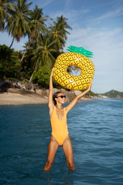 Vista frontal mujer sonriente con flotador de piña