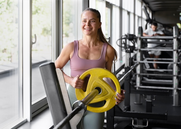 Foto gratuita vista frontal mujer sonriente en el gimnasio