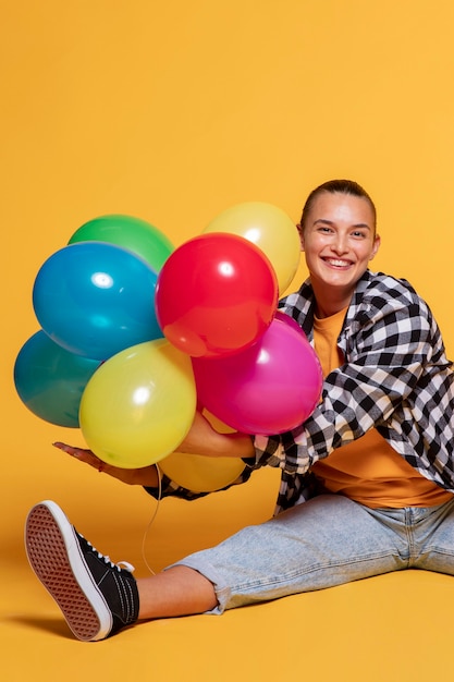 Vista frontal de la mujer sonriente con globos