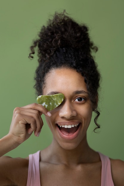 Vista frontal mujer sonriente con gua sha