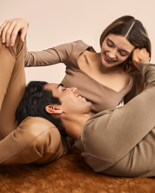 Vista frontal de la mujer sonriente con el hombre descansando su cabeza en su regazo