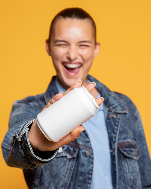 Vista frontal de la mujer sonriente con lata de refresco