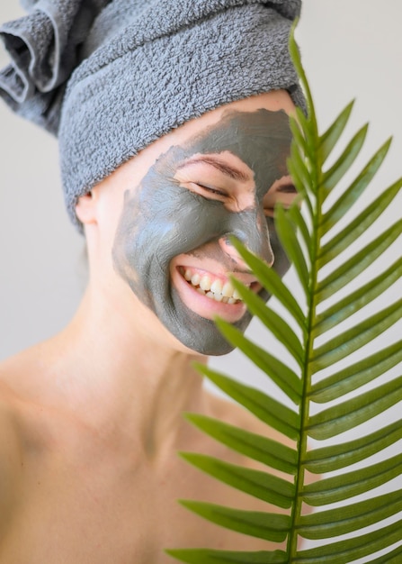 Vista frontal de la mujer sonriente con mascarilla en casa