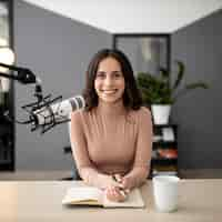 Foto gratuita vista frontal de la mujer sonriente con micrófono en un estudio de radio