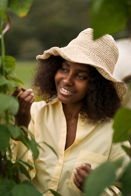 Foto gratuita vista frontal mujer sonriente mirando la planta