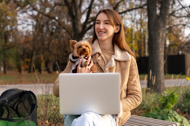 Vista frontal mujer sonriente con perro al aire libre