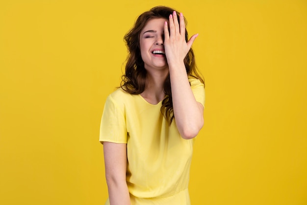 Vista frontal de la mujer sonriente que cubre la mitad de su rostro