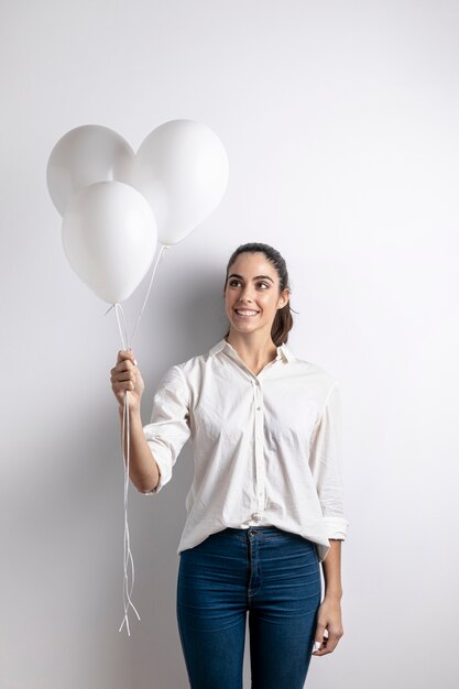 Vista frontal de la mujer sonriente que sostiene los globos