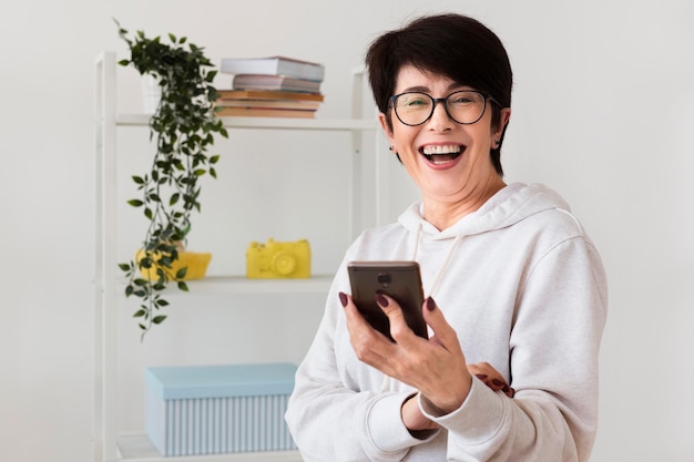 Vista frontal de la mujer sonriente con smartphone