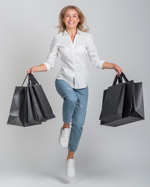 Foto gratuita vista frontal de la mujer sonriente sosteniendo muchas bolsas de la compra.