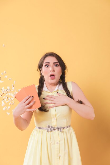 Vista frontal de la mujer sorprendida derramando palomitas de maíz