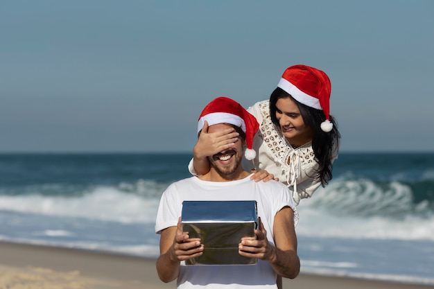 Vista frontal mujer sorprendiendo a hombre con regalo