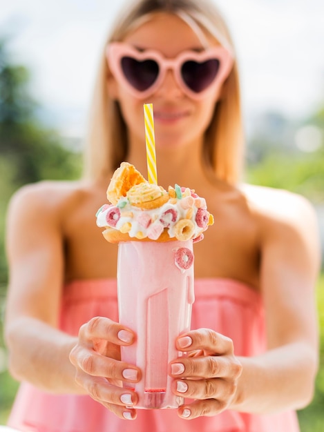 Foto gratuita vista frontal mujer sosteniendo batido