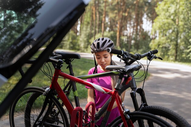 Vista frontal mujer sosteniendo bicicleta