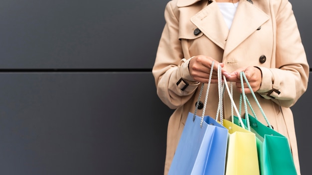 Vista frontal de la mujer sosteniendo bolsas de la compra con espacio de copia