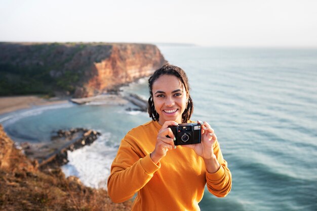 Foto gratuita vista frontal mujer sosteniendo la cámara