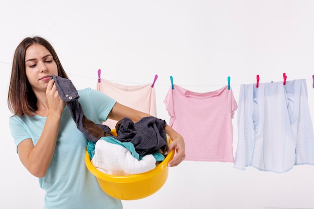 Vista frontal mujer sosteniendo una cesta de lavandería amarilla