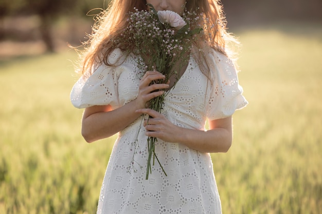 Foto gratuita vista frontal mujer sosteniendo flores