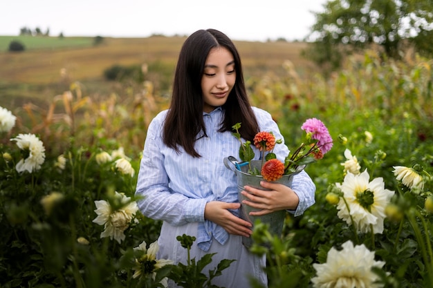 Foto gratuita vista frontal mujer sosteniendo flores