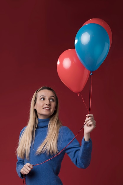 Vista frontal mujer sosteniendo globos