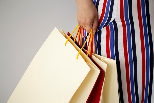 Vista frontal de la mujer sosteniendo un montón de bolsas de la compra.