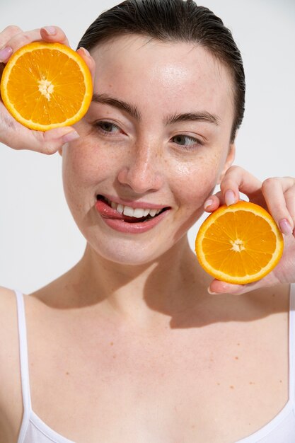 Vista frontal mujer sosteniendo naranja