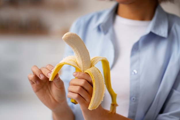 Foto gratuita vista frontal mujer sosteniendo plátano