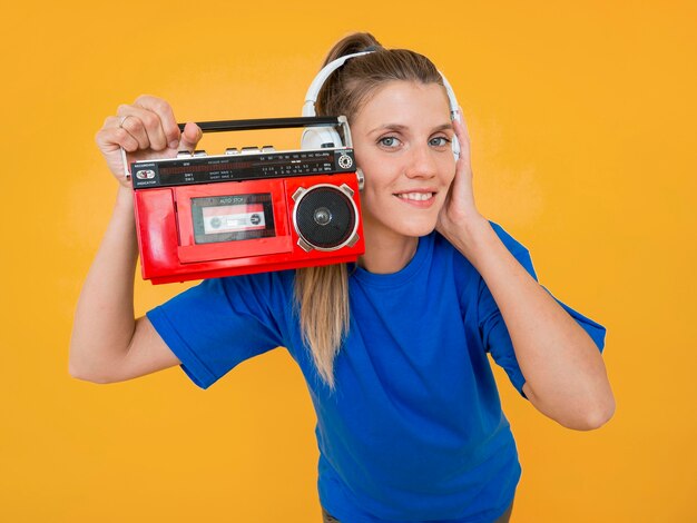 Vista frontal de la mujer sosteniendo una radio