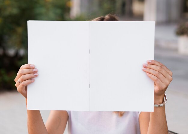 Vista frontal mujer sosteniendo una revista de maquetas