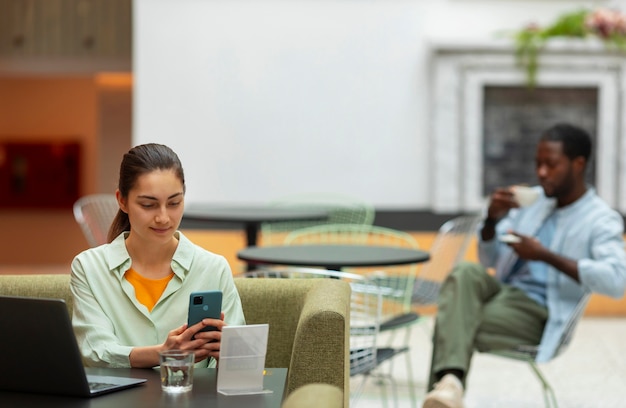 Foto gratuita vista frontal mujer sosteniendo smartphone