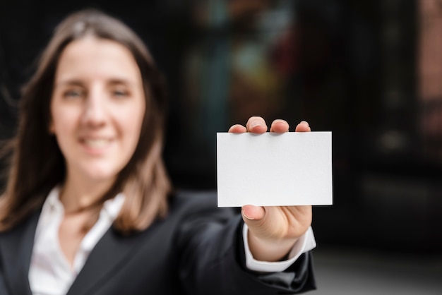 Vista frontal mujer sosteniendo una tarjeta de visita