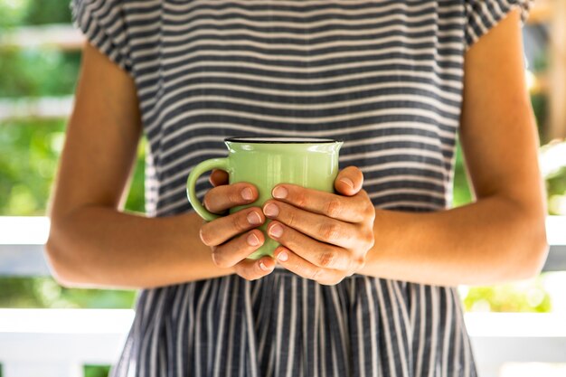 Foto gratuita vista frontal mujer sosteniendo la taza de café