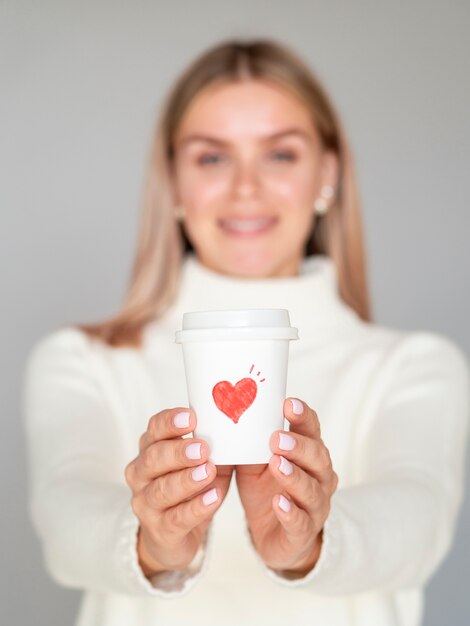 Vista frontal mujer sosteniendo la taza de café