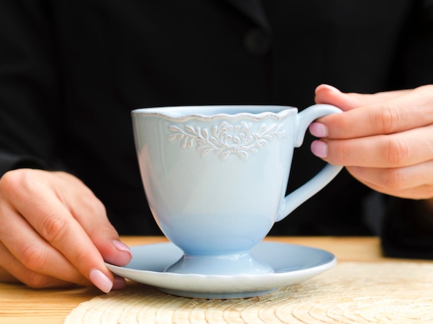 Vista frontal mujer sosteniendo la taza de té azul