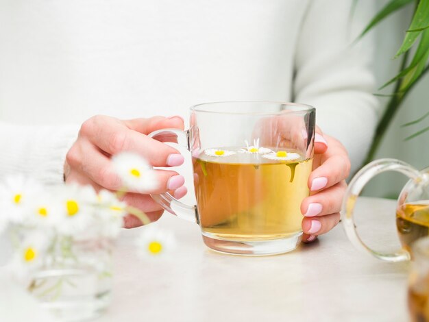 Vista frontal mujer sosteniendo té en vaso