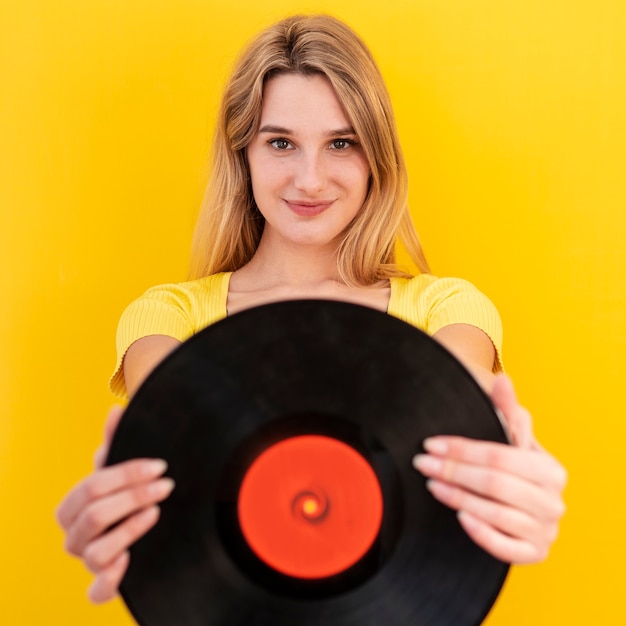 Foto gratuita vista frontal mujer sosteniendo vinilo