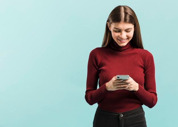 Vista frontal mujer en su teléfono