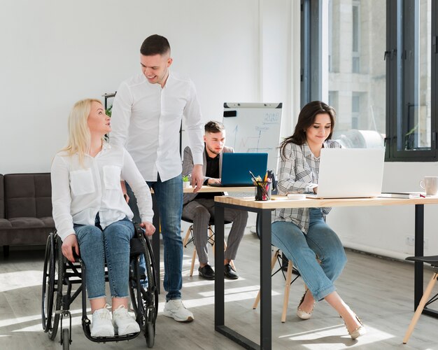 Vista frontal de la mujer con sus compañeros de trabajo en la oficina