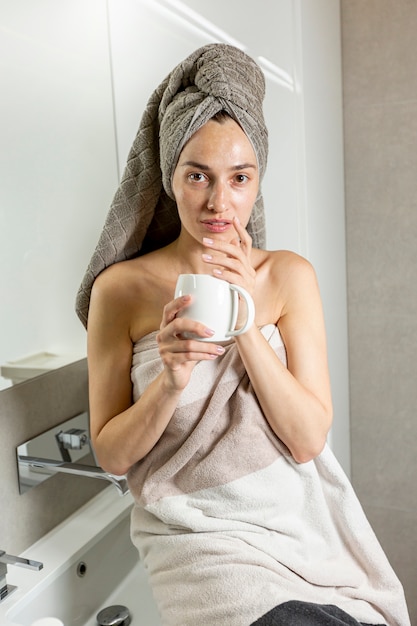 Foto gratuita vista frontal mujer con toalla en el baño