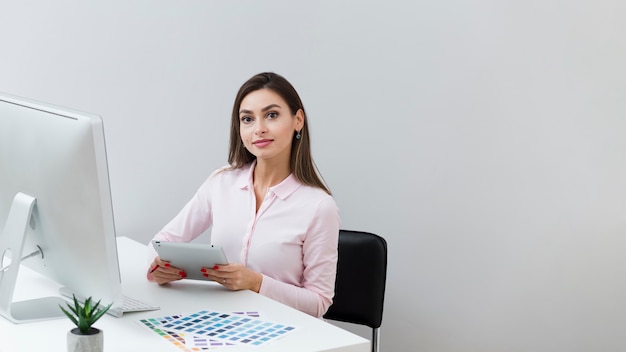 Vista frontal de la mujer en el trabajo sosteniendo una tableta