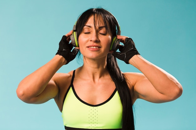 Vista frontal de la mujer en traje de gimnasio con auriculares