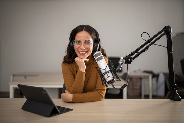 Vista frontal de la mujer transmitiendo en radio