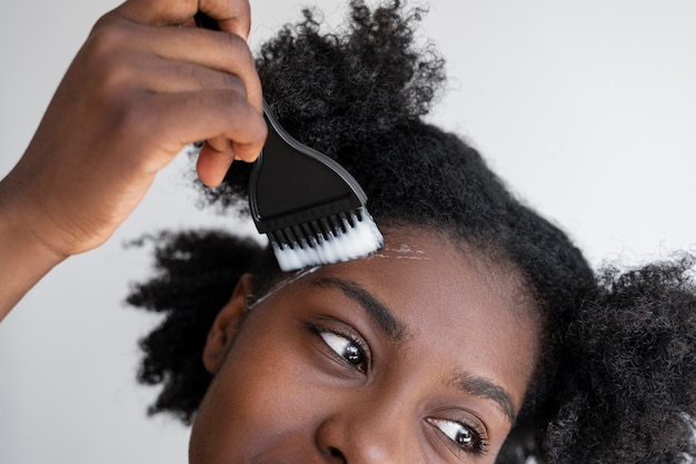 Vista frontal mujer usando producto para el cabello
