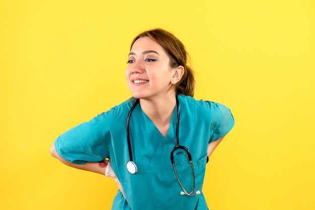 Vista frontal de la mujer veterinaria sonriendo sobre pared amarilla