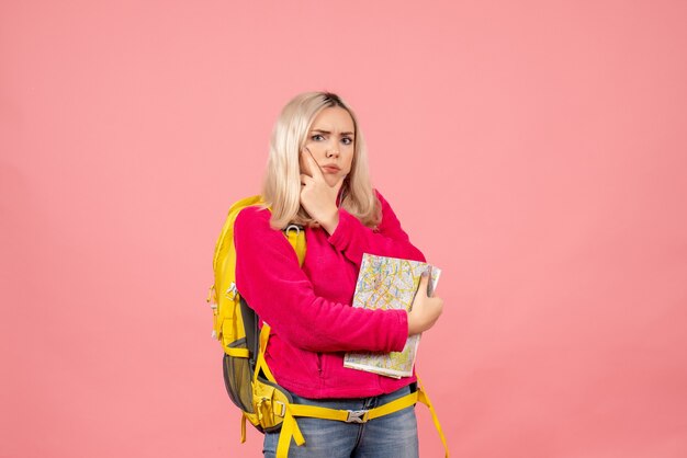 Vista frontal mujer viajera confundida con mochila amarilla con mapa