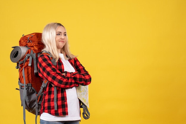 Foto gratuita vista frontal mujer viajera confundida con su mochila cruzando las manos de pie sobre la pared amarilla