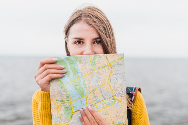 Vista frontal de la mujer viajera con mapa