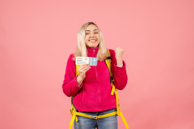 Vista frontal mujer viajera muy emocionada en ropa casual con mochila con boleto