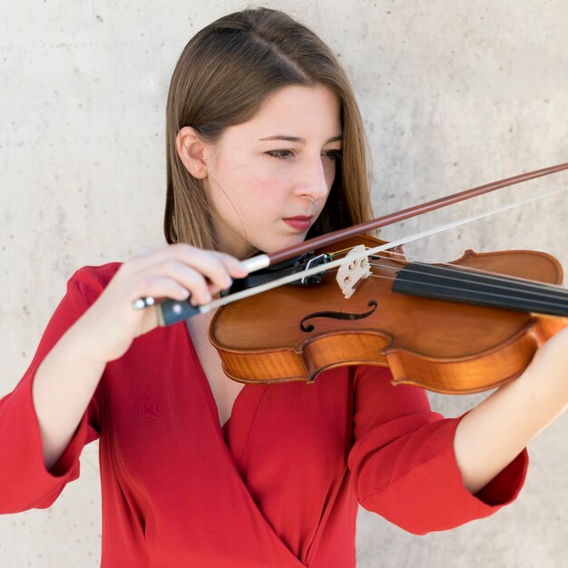 Vista frontal de la mujer violinista tocando